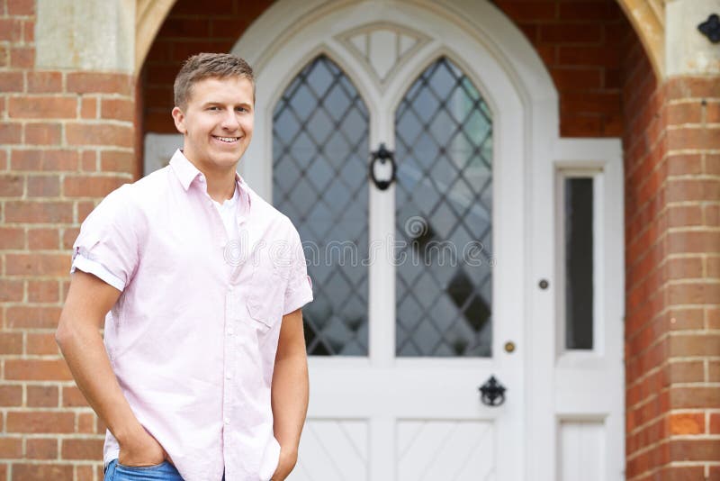 Portrait Of Man Standing Outside Front Door Of Home. Man Standing Outside Front Door Of Home stock photo